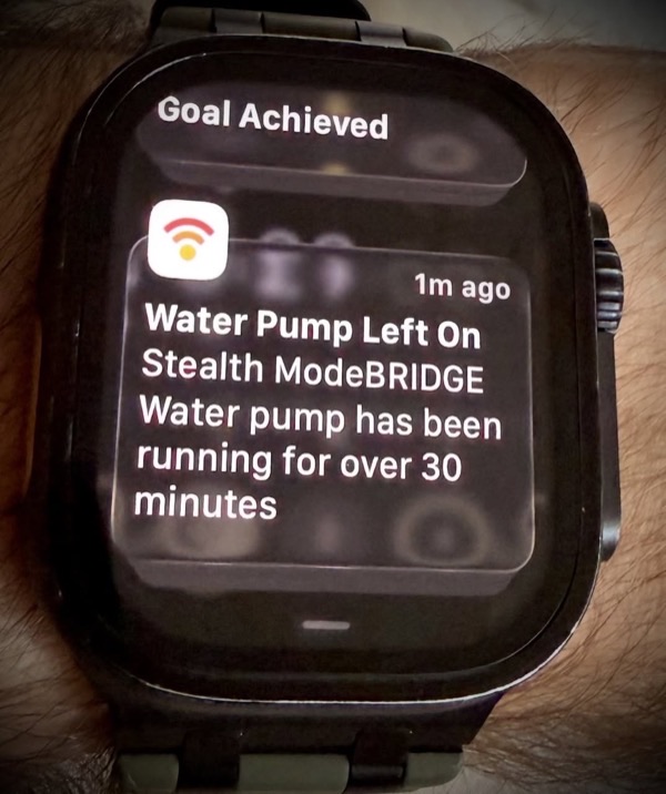 An Apple Watch notification from ModeBRIDGE reading 'Water Pump Left On — Stealth ModeBRIDGE water pump has been running for over 30 minutes.'